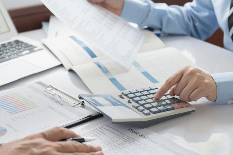 Two,Colleagues,Analyzing,Financial,Data,Reports,On,Laptop,With,Charts